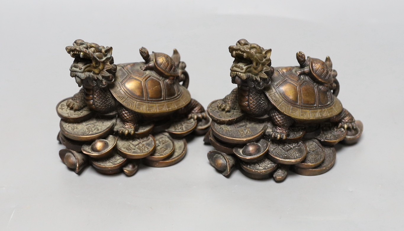 Two Chinese bronze models of dragon turtles on a pile of cash, 10cm